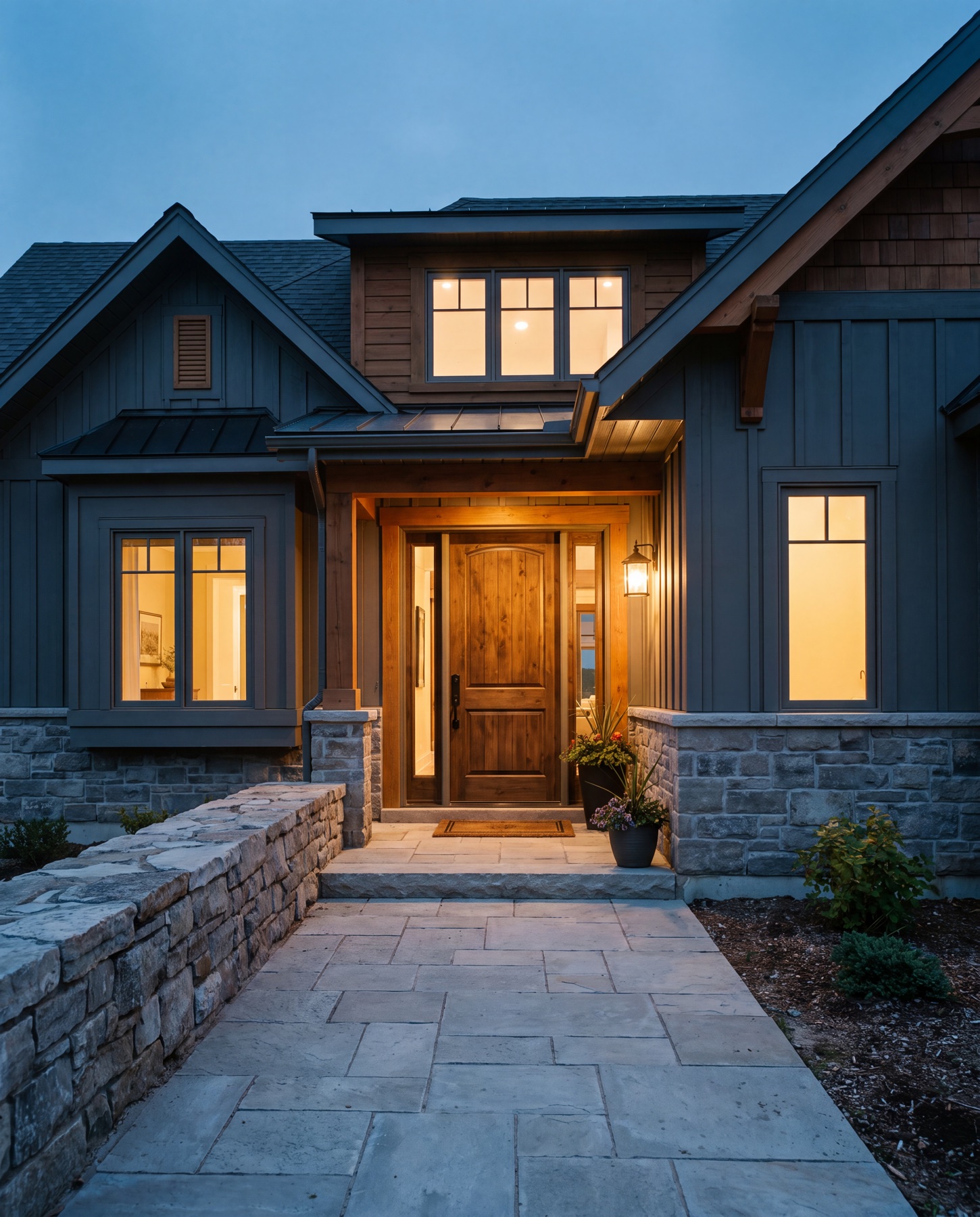 A just-completed Ontario home at dusk with warm interior light and a stone entry walkway.